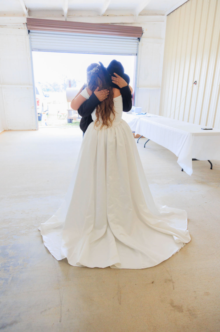 Jaelyn & Keelan's wedding at Reverie at Diamond D — the bride and groom sharing a private embrace in the reception barn