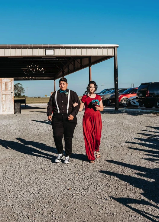 Attendants in red and black walking down the gravel drive from the covered pavilion