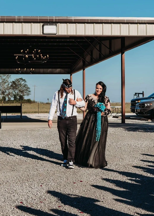Couple walking arm in arm past the covered pavilion and its chandelier