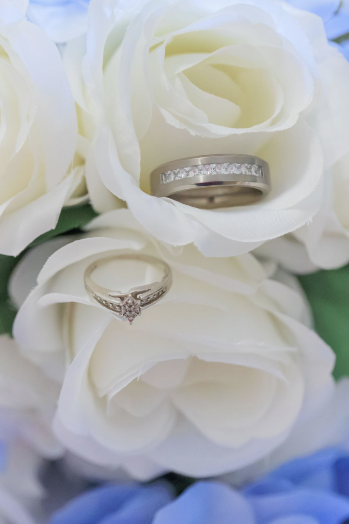Jaelyn & Keelan's wedding at Reverie at Diamond D — the wedding rings nestled in white roses