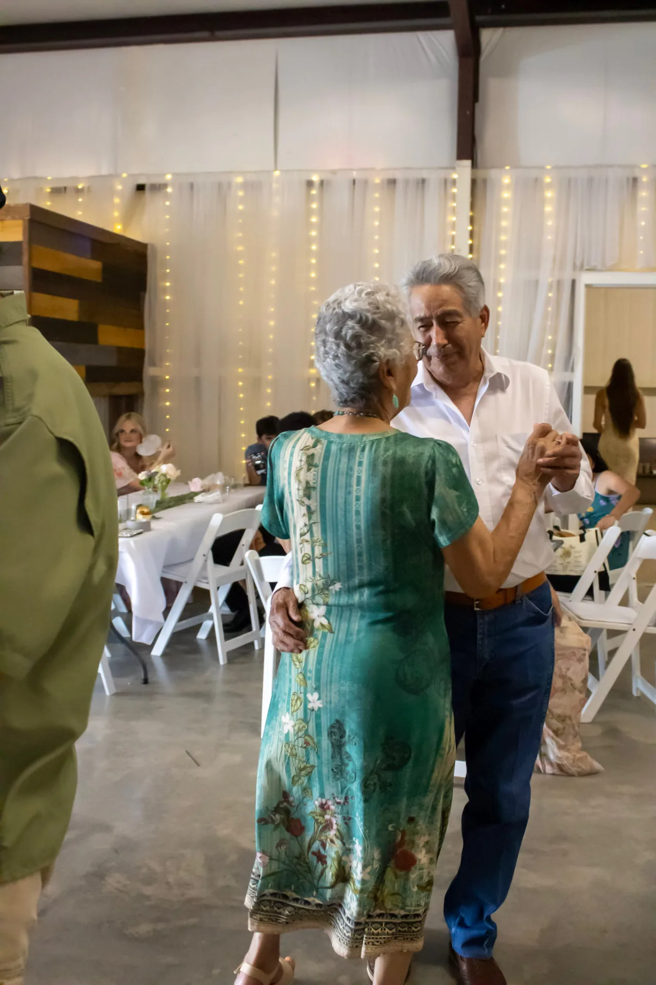 Couple sharing a slow dance in front of twinkle-light draping at the Bryanna and Richard reception