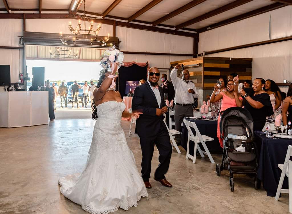 Newlyweds' grand entrance as guests cheer inside the barn
