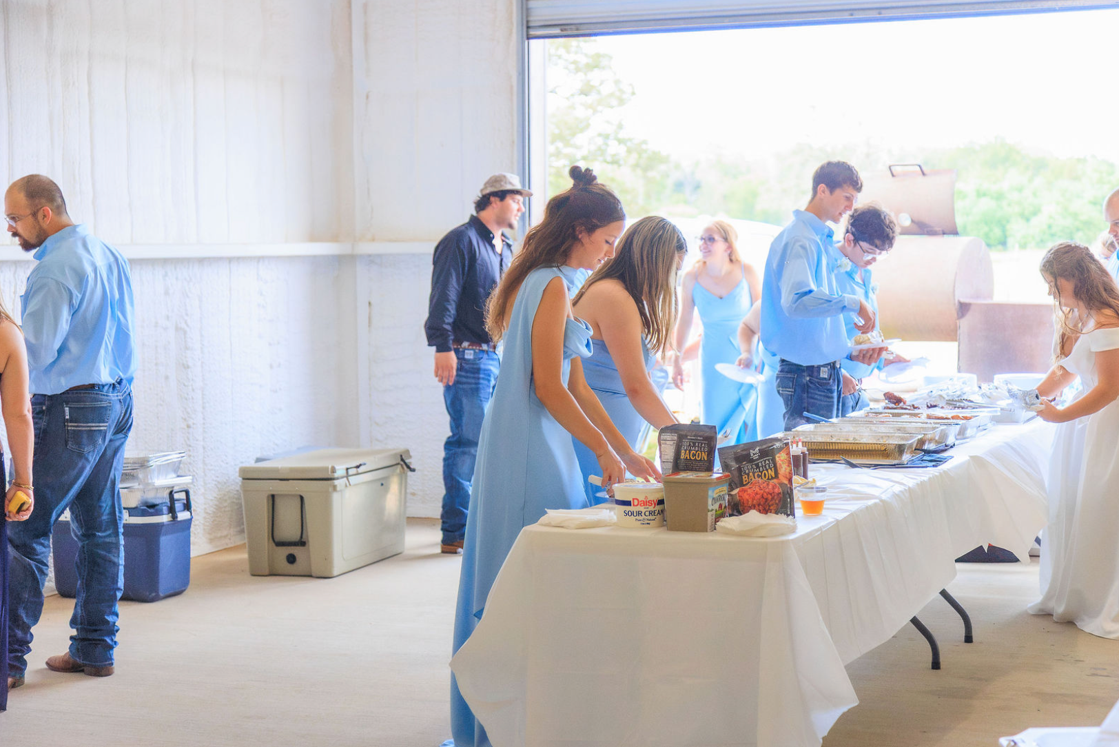 Jaelyn & Keelan's wedding at Reverie at Diamond D — guests serving themselves at the buffet line in the reception barn