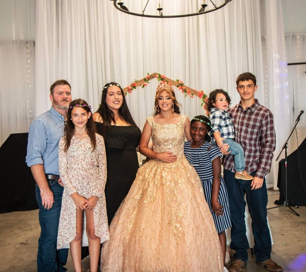 Family portrait in front of the floral arch and draped wall at Bryanna's Sweet 16