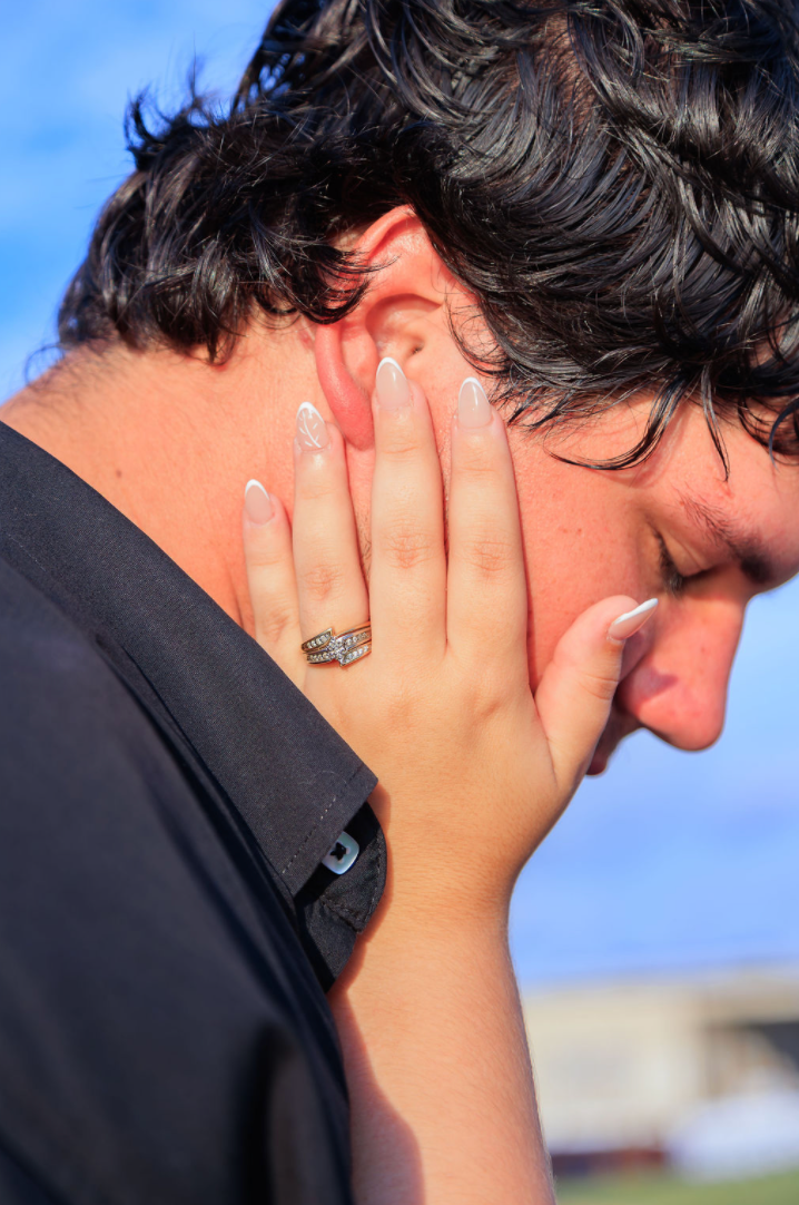 Jaelyn & Keelan's wedding at Reverie at Diamond D — the bride's hand with her engagement ring resting on the groom's cheek