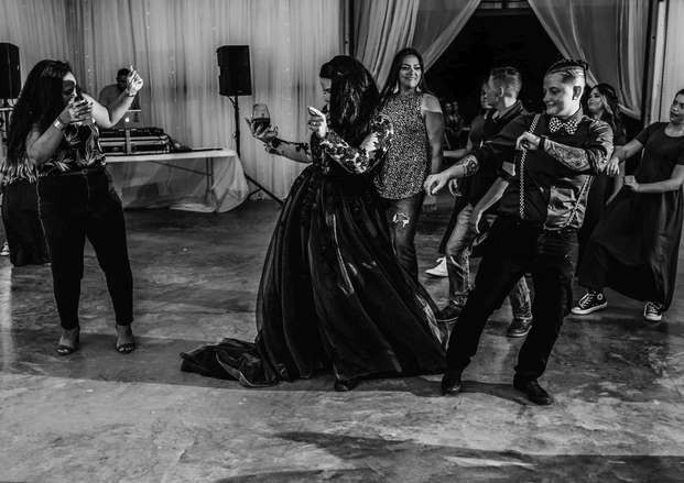 Black and white photo of guests dancing on the polished concrete reception floor