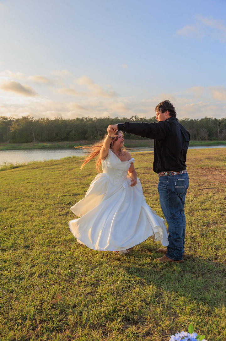 Jaelyn & Keelan's wedding at Reverie at Diamond D — the groom twirling the bride in the grass by the lake at golden hour